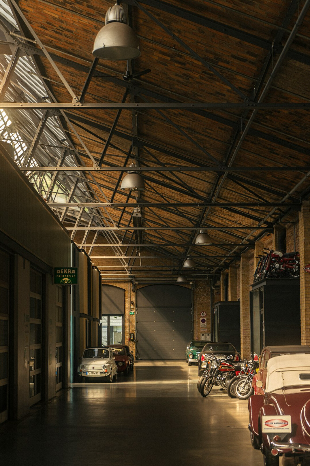 Dimly lit historic garage filled with covered vintage automobiles