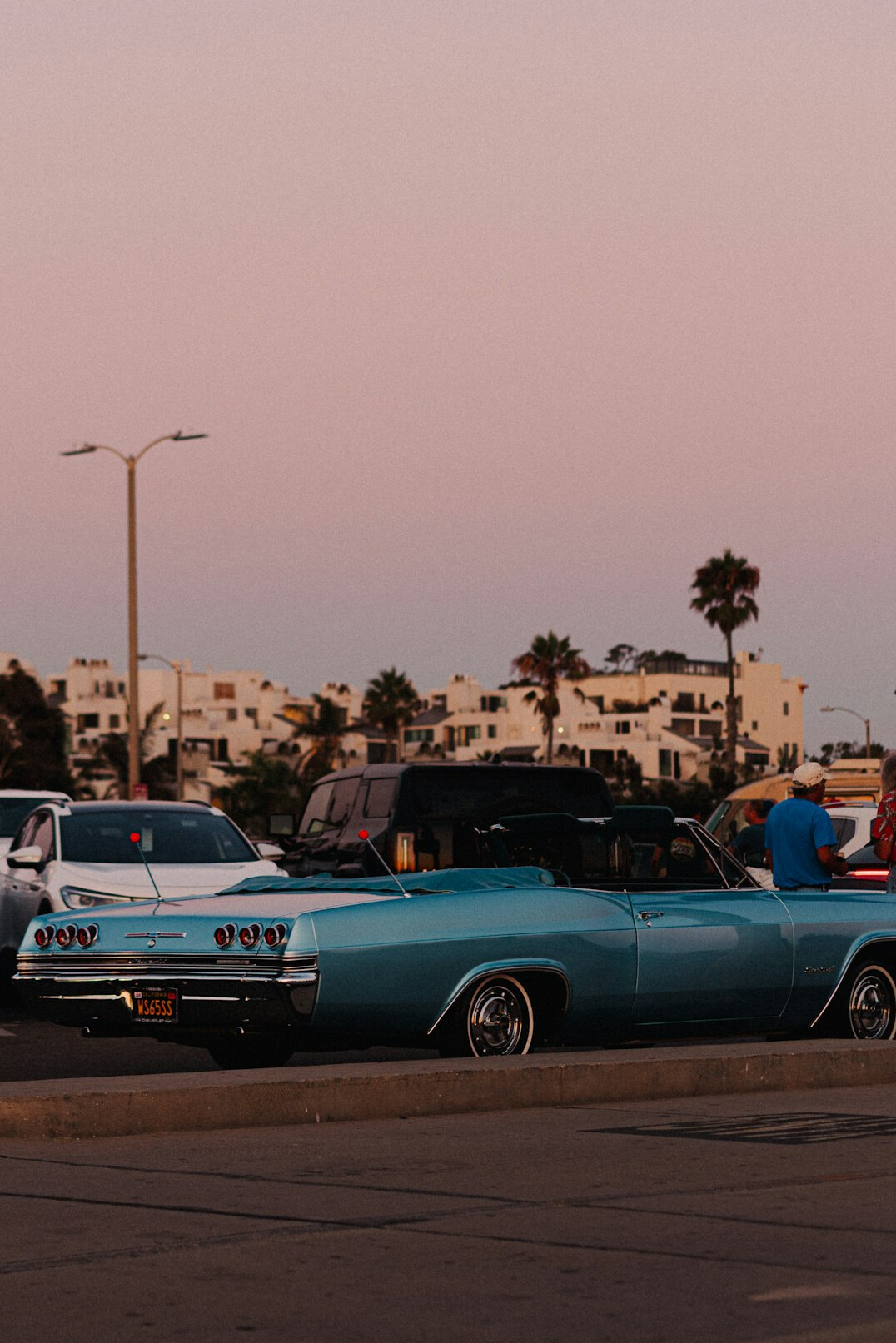 Vintage sports car driving along a coastal road in Punta del Este at dusk