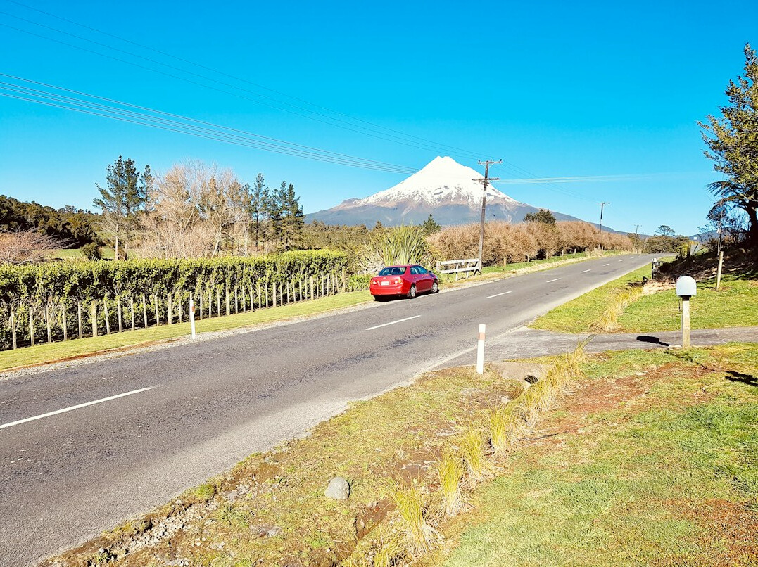 A red vintage Italian sports car parked on a quiet Uruguayan road