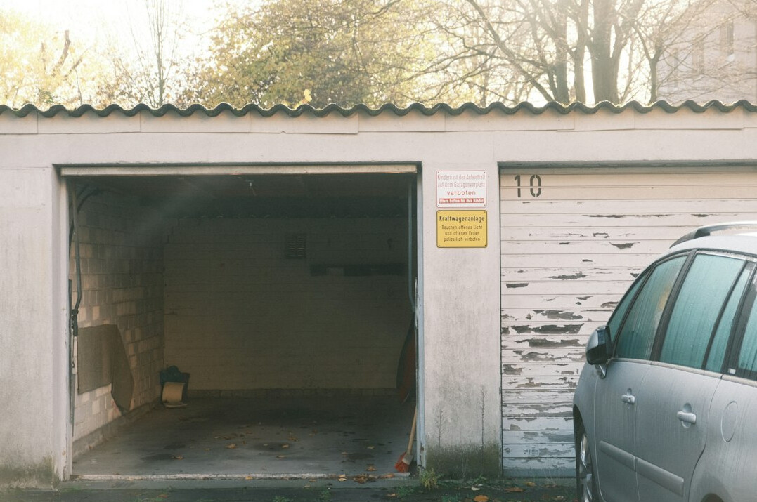 Mysterious private garage with several automobiles covered by dust sheets